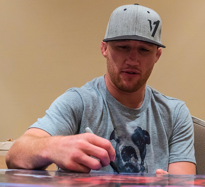 Justin Gaethje signs posters at fighter check-ins for Fight Night Lincoln