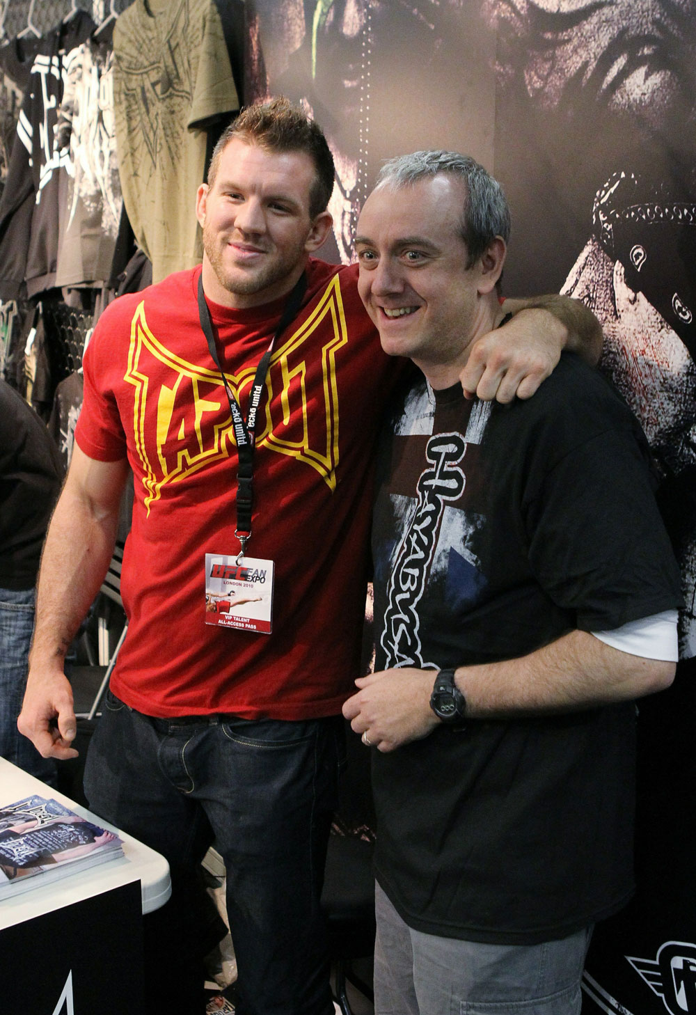 UFC Light Heavyweight fighter Ryan Bader (L) poses for a photo with a fan at the TapouT booth.
