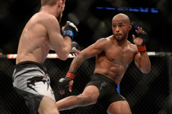 VANCOUVER, BC - JUNE 14: (R-L) UFC Flyweight Champion Demetrious 'Mighty Mouse' Johnson kicks Ali Bagautinov during their flyweight championship bout at the UFC 174 event at Rogers Arena on June 14, 2014 in Vancouver, British Columbia, Canada. (Photo by Jeff Bottari/Zuffa LLC/Zuffa LLC via Getty Images)