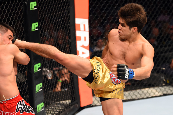 DALLAS, TX - MARCH 14: (R-L) Henry Cejudo kicks the head of <a href='../fighter/Chris-Cariaso'>Chris Cariaso</a> in their flyweight bout during the UFC 185 event at the American Airlines Center on March 14, 2015 in Dallas, Texas. (Photo by Josh Hedges/Zuffa LLC/Zuffa LLC)