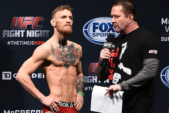 Conor 'The Notorious' McGregor of Ireland (L) speaks with UFC commentator Mike Goldberg during the UFC Fight Night Boston weigh-in event at the Orpheum Theatre on January 17, 2015 in Boston, Massachusetts. (Photo by Jeff Bottari/Zuffa LLC)