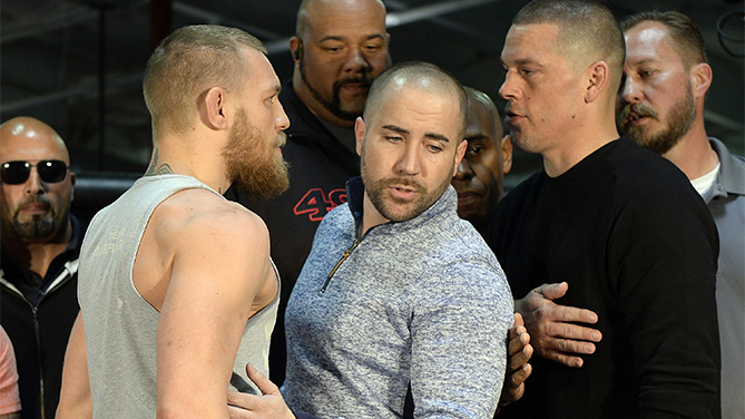 UFC featherweight champion Conor McGregor (L) and lightweight contender Nate Diaz (R) are held apart by Dave Sholler (C), UFC vice president of public relations, after a news conference at UFC Gym February 24, 2016, in Torrance, California. (Photo by Kevork Djansezian/Getty Images)