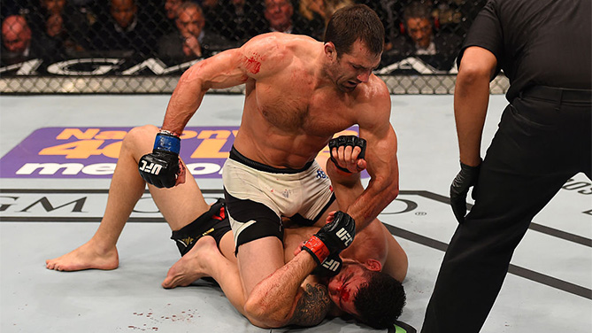 LAS VEGAS, NV - DECEMBER 12:Luke Rockhold (top) punches Chris Weidman in their UFC middleweight championship bout during the UFC 194 event inside MGM Grand Garden Arena on December 12, 2015 in Las Vegas, Nevada. (Photo by Josh Hedges/Zuffa LLC)