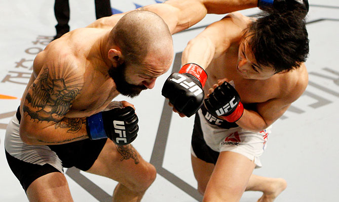 SEOUL, SOUTH KOREA - NOV. 28: <a href='../fighter/Dooho-Choi'>Doo Ho Choi</a> of South Korea punches <a href='../fighter/Sam-Sicilia'>Sam Sicilia</a> of the United States of America in their featherweight bout during the <a href='../event/UFC-Silva-vs-Irvin'>UFC Fight Night </a>at the Olympic Park Gymnastics Arena. (Photo by Mitch Viquez/Zuffa LLC)