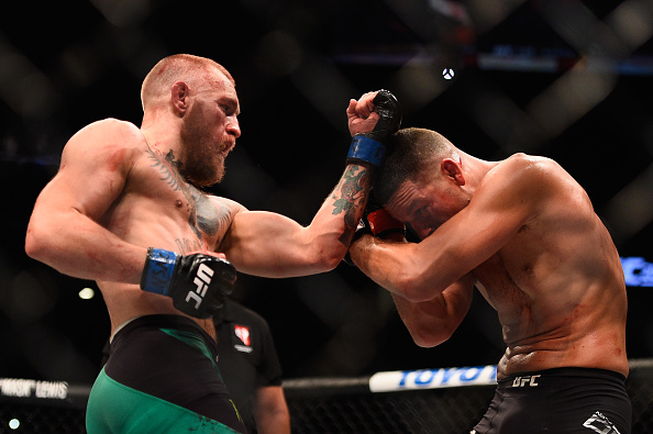 Conor McGregor punches Nate Diaz during their rematch at UFC 202
