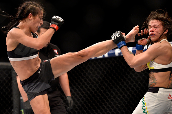 <a href='../fighter/Joanna-Jedrzejczyk'>Joanna Jedrzejczyk</a> lands a kick to <a href='../fighter/Claudia-Gadelha'>Claudia Gadelha</a> during their strawweight title fight in July