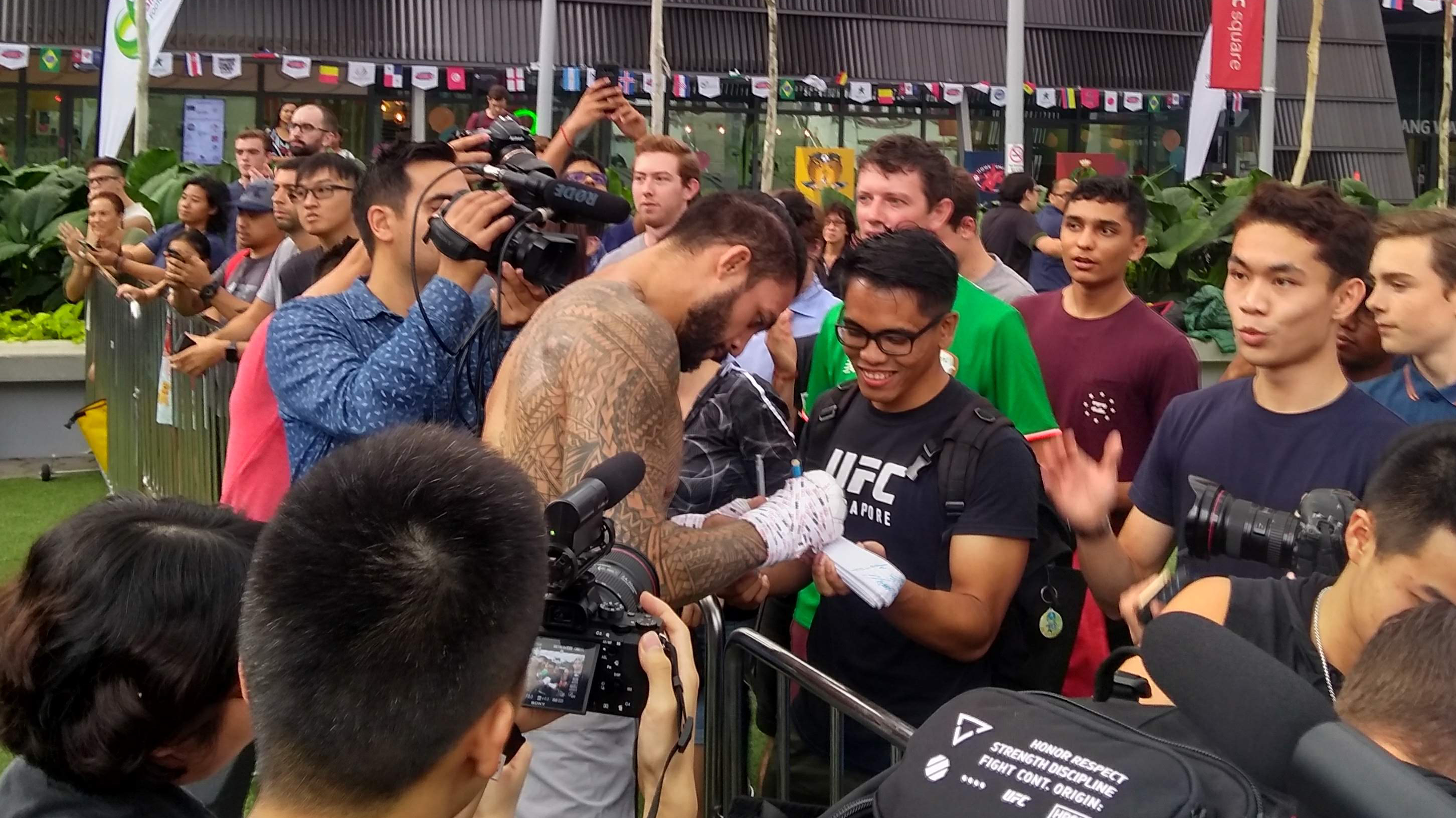 <a href='../fighter/tyson-pedro'>Tyson Pedro</a> signs autographs for fans following his open workout for Fight Night Singapore on 6/20/18 (Photo by Steve Latrell/Zuffa LLC)