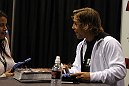 Urijah Faber signs gloves for a fan