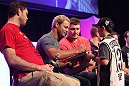 Josh Koscheck signs an autograph for a young fan during a Q&A session at the UFC Fan Expo
