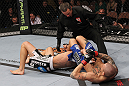 LAS VEGAS, NV - FEBRUARY 04:  Dustin Poirier (right) attempts to submit Max Holloway as referee Steve Mazzagatti looks on during the UFC 143 event at Mandalay Bay Events Center on February 4, 2012 in Las Vegas, Nevada.  (Photo by Nick Laham/Zuffa LLC/Zuffa LLC via Getty Images) *** Local Caption *** Dustin Poirier; Steve Mazzagatti