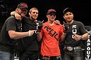 OMAHA, NE - FEBRUARY 15:  TJ Dillashaw (orange shirt) poses for a photo with his team after defeating Walel Watson during the UFC on FUEL TV event at Omaha Civic Auditorium on February 15, 2012 in Omaha, Nebraska.  (Photo by Josh Hedges/Zuffa LLC/Zuffa LLC via Getty Images) *** Local Caption *** TJ Dillashaw; Urijah Faber
