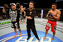 LAS VEGAS, NV - JULY 7:   Referee Mario Yamasaki (center) raises Rafaello Oliveira's (left) hand after his victory over Yoislandy Izquierdo during their lightweight bout at UFC 148 inside MGM Grand Garden Arena on July 7, 2012 in Las Vegas, Nevada.  (Photo by Donald Miralle/Zuffa LLC/Zuffa LLC via Getty Images)  *** Local Caption *** Yoislandy Izquierdo; Rafaello Oliveira