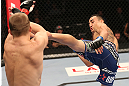 DENVER, CO - AUGUST 11:  (R-L) Max Holloway kicks Justin Lawrence during their featherweight bout at UFC 150 inside Pepsi Center on August 11, 2012 in Denver, Colorado. (Photo by Nick Laham/Zuffa LLC/Zuffa LLC via Getty Images)