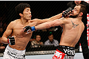 MACAU, MACAU - NOVEMBER 10:  (L-R) Takeya Mizugaki punches Jeff Hougland during their bantamweight bout at the UFC Macao event inside CotaiArena on November 10, 2012 in Macau, Macau.  (Photo by Josh Hedges/Zuffa LLC/Zuffa LLC via Getty Images)