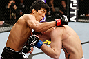 SAITAMA, JAPAN - MARCH 03:  (L-R) Takeya Mizugaki punches Bryan Caraway in their bantamweight fight during the UFC on FUEL TV event at Saitama Super Arena on March 3, 2013 in Saitama, Japan.  (Photo by Josh Hedges/Zuffa LLC/Zuffa LLC via Getty Images)