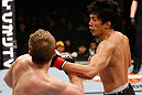 SAITAMA, JAPAN - MARCH 03:  (R-L) Takeya Mizugaki punches Bryan Caraway in their bantamweight fight during the UFC on FUEL TV event at Saitama Super Arena on March 3, 2013 in Saitama, Japan.  (Photo by Josh Hedges/Zuffa LLC/Zuffa LLC via Getty Images)