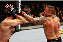 STOCKHOLM, SWEDEN - APRIL 06:  (R-L) Ross Pearson punches Ryan Couture in their lightweight fight at the Ericsson Globe Arena on April 6, 2013 in Stockholm, Sweden.  (Photo by Josh Hedges/Zuffa LLC/Zuffa LLC via Getty Images)