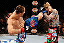 LAS VEGAS, NV - APRIL 13:   (L-R) Cole Miller kicks Bart Palaszewski in their featherweight fight at the Mandalay Bay Events Center  on April 13, 2013 in Las Vegas, Nevada.  (Photo by Josh Hedges/Zuffa LLC/Zuffa LLC via Getty Images)  *** Local Caption *** Cole Miller; Bart Palaszewski