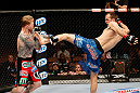 LAS VEGAS, NV - APRIL 13:   (R-L) Cole Miller kicks Bart Palaszewski in their featherweight fight at the Mandalay Bay Events Center  on April 13, 2013 in Las Vegas, Nevada.  (Photo by Josh Hedges/Zuffa LLC/Zuffa LLC via Getty Images)  *** Local Caption *** Cole Miller; Bart Palaszewski
