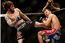 NEWARK, NJ - APRIL 27:   (L-R) Johny Bedford kicks Bryan Caraway in their bantamweight fight during the UFC 159 event at the Prudential Center on April 27, 2013 in Newark, New Jersey.  (Photo by Josh Hedges/Zuffa LLC/Zuffa LLC via Getty Images)
