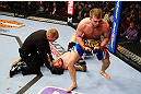 NEWARK, NJ - APRIL 27:  Bryan Caraway (R) celebrates winning by submission (guillotine choke) against Johnny Bedford (C) in their bantamweight bout during the UFC 159 event at the Prudential Center on April 27, 2013 in Newark, New Jersey.  (Photo by Al Bello/Zuffa LLC/Zuffa LLC Via Getty Images)