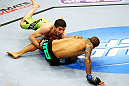 NEWARK, NJ - APRIL 27:  (L-R) Rustam Khabilov of Russia takes down Yancy Medeiros who breaks his fall with his hands injuring himself in their lightweight bout during the UFC 159 event at the Prudential Center on April 27, 2013 in Newark, New Jersey.  (Photo by Al Bello/Zuffa LLC/Zuffa LLC Via Getty Images)