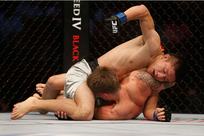 HOUSTON, TEXAS - OCTOBER 19:  Kyoji Horiguchi (top) punches Dustin Pague in their UFC bantamweight bout at the Toyota Center on October 19, 2013 in Houston, Texas. (Photo by Josh Hedges/Zuffa LLC/Zuffa LLC via Getty Images)