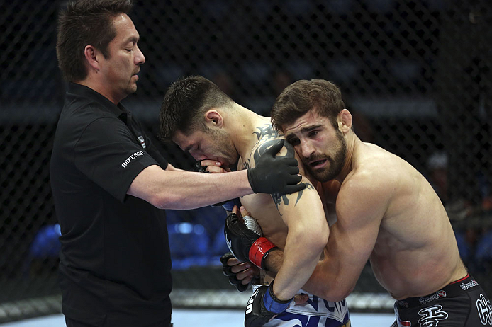 CALGARY, CANADA - JULY 21:  (L-R) Referee Mario Yamasaki holds Daniel Pineda up as Antonio Carvalho hugs him after knocking Pineda out in the first round during their featherweight bout at UFC 149 inside the Scotiabank Saddledome on July 21, 2012 in Calgary, Alberta, Canada.  (Photo by Nick Laham/Zuffa LLC/Zuffa LLC via Getty Images)