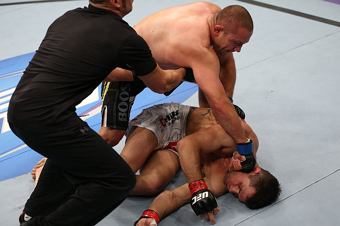 MINNEAPOLIS, MN - OCTOBER 05: (L-R) Mike Pierce knocks out Aaron Simpson with a series of punches during their welterweight fight at the UFC on FX event at Target Center on October 5, 2012 in Minneapolis, Minnesota. (Photo by Josh Hedges/Zuffa LLC/Zuffa LLC via Getty Images)
