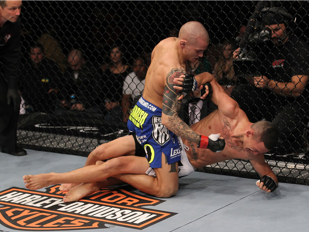 LAS VEGAS, NV - FEBRUARY 04:  Dustin Poirier (blue shorts) delivers punches to Max Holloway from the mount during the UFC 143 event at Mandalay Bay Events Center on February 4, 2012 in Las Vegas, Nevada.  (Photo by Nick Laham/Zuffa LLC/Zuffa LLC via Getty Images) *** Local Caption *** Dustin Poirier; Max Holloway