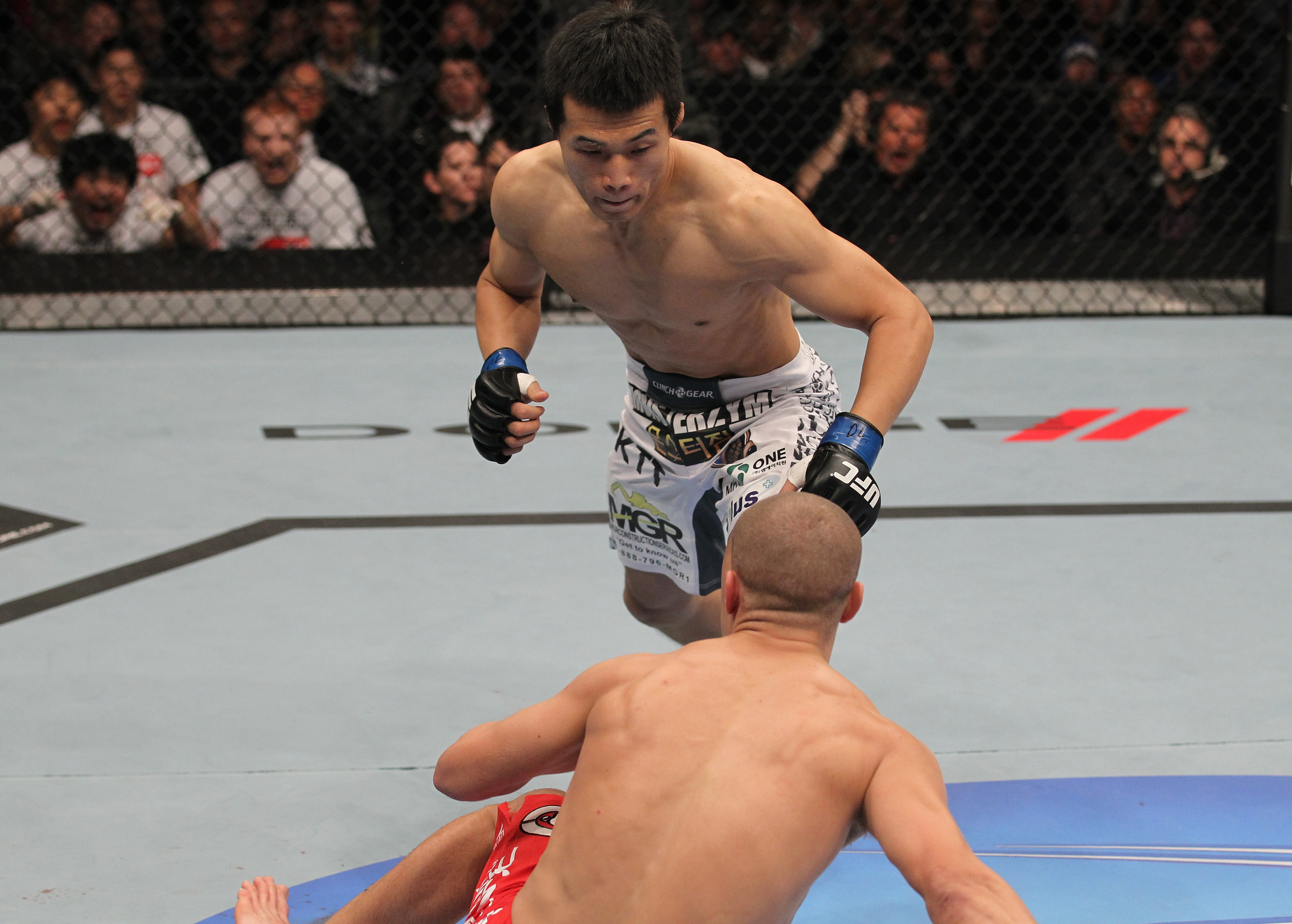 TORONTO, ON - DECEMBER 10:  (L-R) "The Korean Zombie" Chan Sung Jung rushes in to finish Mark Hominick after knocking him down with a punch during the UFC 140 event at Air Canada Centre on December 10, 2011 in Toronto, Ontario, Canada.  (Photo by Nick Laham/Zuffa LLC/Zuffa LLC via Getty Images)
