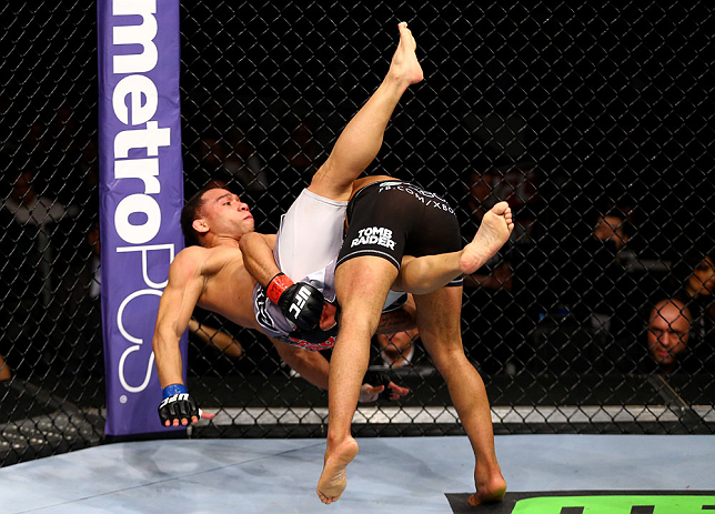 CHICAGO, IL - JANUARY 26:  John Dodson (L) gets dumped by Demetrious Johnson (R) during thier Flyweight Championship Bout part of UFC on FOX at United Center on January 26, 2013 in Chicago, Illinois.  (Photo by Al Bello/Zuffa LLC/Zuffa LLC Via Getty Images)
