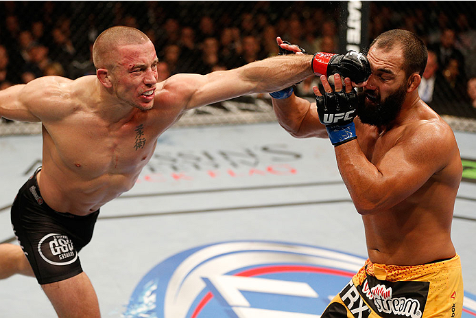 LAS VEGAS, NV - NOVEMBER 16:  (L-R) Georges St-Pierre punches Johny Hendricks in their UFC welterweight championship bout during the UFC 167 event inside the MGM Grand Garden Arena on November 16, 2013 in Las Vegas, Nevada. (Photo by Josh Hedges/Zuffa LLC/Zuffa LLC via Getty Images) *** Local Caption *** Georges St-Pierre; Johny Hendricks