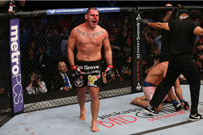 HOUSTON, TEXAS - OCTOBER 19:  Cain Velasquez (black shorts) celebrates after defeating Junior Dos Santos by TKO after referee Herb Dean calls a stop to the fight in their UFC heavyweight championship bout at the Toyota Center on October 19, 2013 in Houston, Texas. (Photo by Nick Laham/Zuffa LLC/Zuffa LLC via Getty Images)