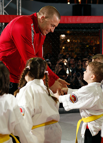 MONTREAL, QC - MARCH 13: UFC welterweight champion Georges St-Pierre greets students of the Sunfuki Karate school during the UFC 158 open workouts at Complexe Desjardins on March 13, 2013 in Montreal, Quebec, Canada. (Photo by Josh Hedges/Zuffa LLC/Zuffa LLC via Getty Images)