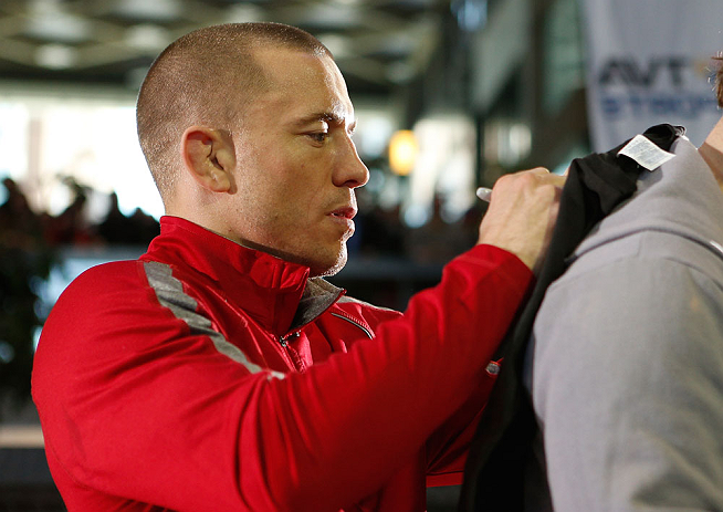 MONTREAL, QC - MARCH 13: UFC welterweight champion Georges St-Pierre signs autographs for fans in attendance during the UFC 158 open workouts at Complexe Desjardins on March 13, 2013 in Montreal, Quebec, Canada. (Photo by Josh Hedges/Zuffa LLC/Zuffa LLC via Getty Images)