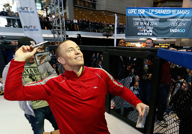 MONTREAL, QC - MARCH 13: UFC welterweight champion Georges St-Pierre tosses autographed DVD's into the crowd during the UFC 158 open workouts at Complexe Desjardins on March 13, 2013 in Montreal, Quebec, Canada. (Photo by Josh Hedges/Zuffa LLC/Zuffa LLC via Getty Images)