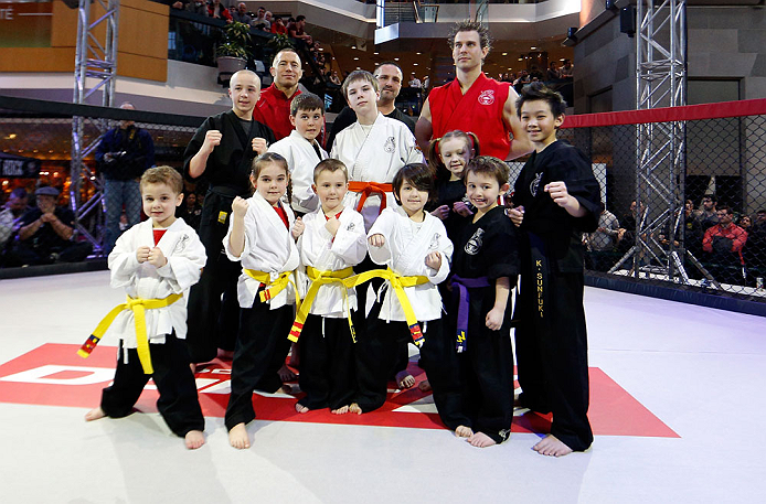 MONTREAL, QC - MARCH 13: UFC welterweight champion Georges St-Pierre poses for photos with students of the Sunfuki Karate school during the UFC 158 open workouts at Complexe Desjardins on March 13, 2013 in Montreal, Quebec, Canada. (Photo by Josh Hedges/Zuffa LLC/Zuffa LLC via Getty Images)