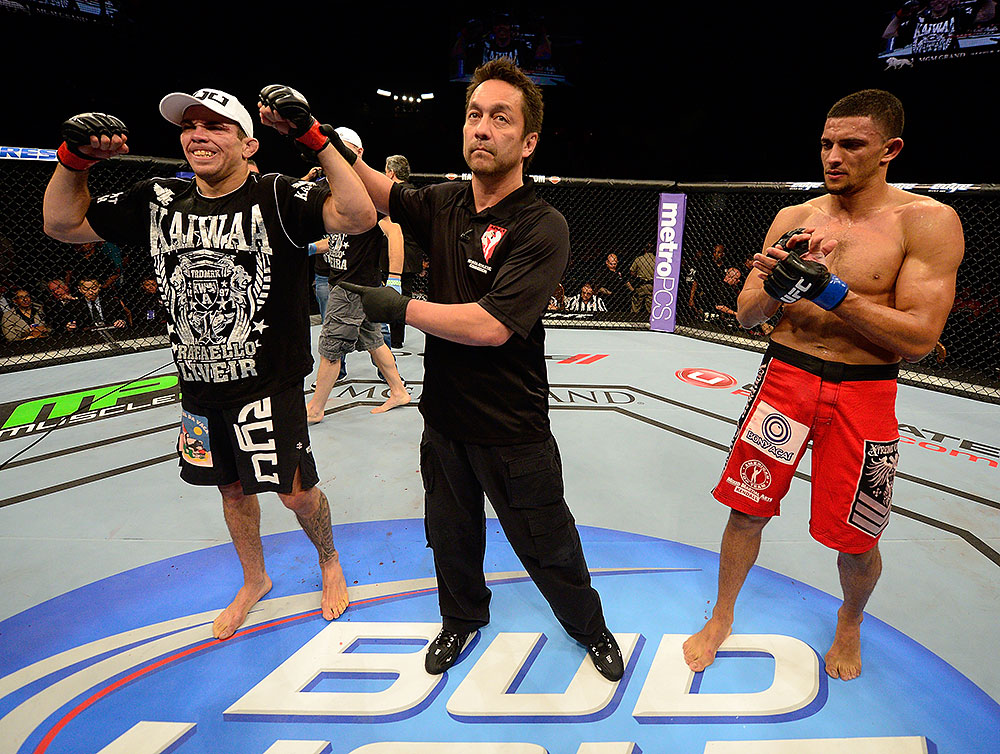 LAS VEGAS, NV - JULY 7:   Referee Mario Yamasaki (center) raises Rafaello Oliveira's (left) hand after his victory over Yoislandy Izquierdo during their lightweight bout at UFC 148 inside MGM Grand Garden Arena on July 7, 2012 in Las Vegas, Nevada.  (Photo by Donald Miralle/Zuffa LLC/Zuffa LLC via Getty Images)  *** Local Caption *** Yoislandy Izquierdo; Rafaello Oliveira