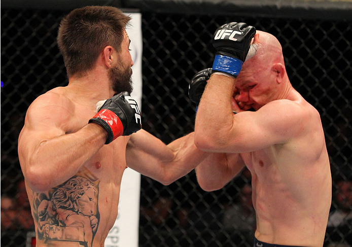 INDIANAPOLIS, IN - AUGUST 28:  (L-R) Carlos Condit punches Martin Kampmann in their welterweight fight during the UFC on FOX Sports 1 event at Bankers Life Fieldhouse on August 28, 2013 in Indianapolis, Indiana. (Photo by Ed Mulholland/Zuffa LLC/Zuffa LLC via Getty Images)