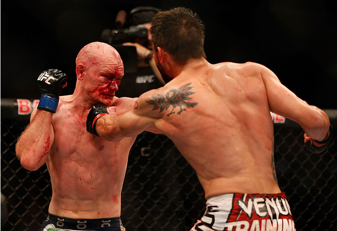 INDIANAPOLIS, IN - AUGUST 28:  (R-L) Carlos Condit punches Martin Kampmann in their welterweight fight during the UFC on FOX Sports 1 event at Bankers Life Fieldhouse on August 28, 2013 in Indianapolis, Indiana. (Photo by Josh Hedges/Zuffa LLC/Zuffa LLC via Getty Images)
