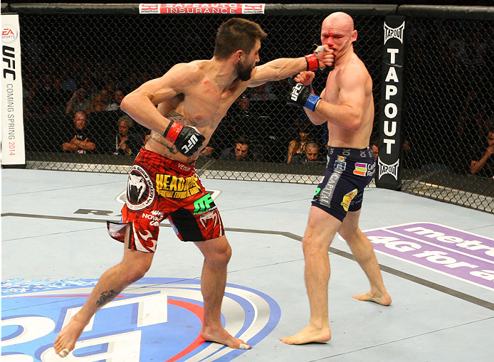 INDIANAPOLIS, IN - AUGUST 28:  (L-R) Carlos Condit punches Martin Kampmann in their welterweight fight during the UFC on FOX Sports 1 event at Bankers Life Fieldhouse on August 28, 2013 in Indianapolis, Indiana. (Photo by Ed Mulholland/Zuffa LLC/Zuffa LLC via Getty Images)