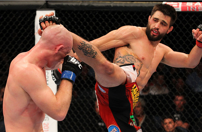 INDIANAPOLIS, IN - AUGUST 28:  (R-L) Carlos Condit kicks Martin Kampmann in their welterweight fight during the UFC on FOX Sports 1 event at Bankers Life Fieldhouse on August 28, 2013 in Indianapolis, Indiana. (Photo by Ed Mulholland/Zuffa LLC/Zuffa LLC via Getty Images)