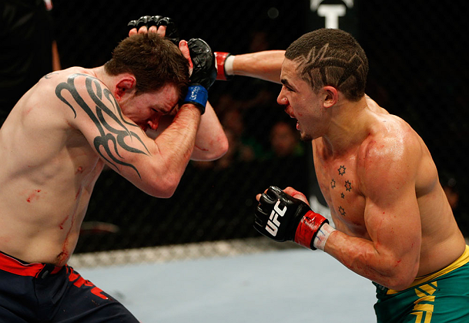 GOLD COAST, AUSTRALIA - DECEMBER 15:  (R-L) Robert Whittaker punches Bradley Scott during their welterweight fight at the UFC on FX event on December 15, 2012  at Gold Coast Convention and Exhibition Centre in Gold Coast, Australia.  (Photo by Josh Hedges/Zuffa LLC/Zuffa LLC via Getty Images)