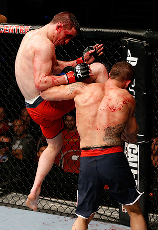 GOLD COAST, AUSTRALIA - DECEMBER 15:  (L-R) Brendan Loughnane delivers a flying knee against Mike Wilkinson during their lightweight fight at the UFC on FX event on December 15, 2012  at Gold Coast Convention and Exhibition Centre in Gold Coast, Australia.  (Photo by Josh Hedges/Zuffa LLC/Zuffa LLC via Getty Images)