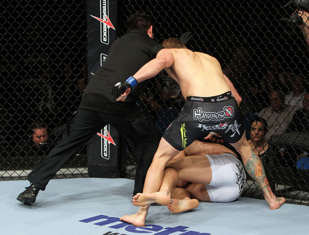 RIO DE JANEIRO, BRAZIL - JANUARY 14: Referee Mario Yamasaki calls the fight as Mike Pyle punches down Ricardo Funch in a welterweight bout during UFC 142 at HSBC Arena on January 14, 2012 in Rio de Janeiro, Brazil. (Photo by Josh Hedges/Zuffa LLC/Zuffa LLC via Getty Images)