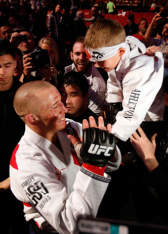 MONTREAL, QC - MARCH 16:  Georges St-Pierre greets a young fan on his way out of the arena after his victory over Nick Diaz in their welterweight championship bout during the UFC 158 event at Bell Centre on March 16, 2013 in Montreal, Quebec, Canada.  (Photo by Josh Hedges/Zuffa LLC/Zuffa LLC via Getty Images)