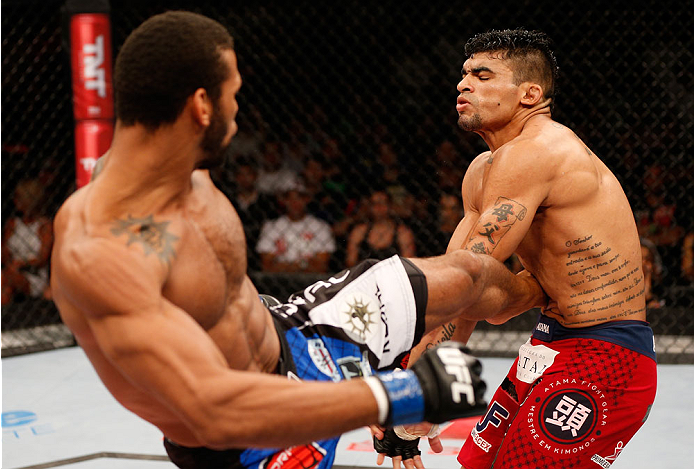 Santos (left) lands a body kick