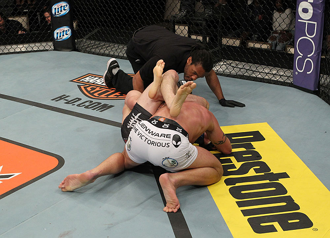 LAS VEGAS, NV - DECEMBER 15: T.J. Walkdburger attempts to submit Nick Catone (white shorts) while referee Herb Dean looks on during their welterweight fight at the TUF 16 Finale on December 15, 2012 at the Joint at the Hard Rock in Las Vegas, Nevada. (Photo by Jim Kemper/Zuffa LLC/Zuffa LLC via Getty Images) *** Local Caption *** T.J. Waldburger; Nick Catone; Herb Dean