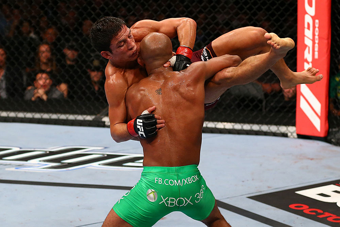 TORONTO, CANADA - SEPTEMBER 22: Demetrious Johnson (green shorts) takes down Joseph Benavidez during their flyweight championship bout at UFC 152 inside Air Canada Centre on September 22, 2012 in Toronto, Ontario, Canada. (Photo by Al Bello/Zuffa LLC/Zuffa LLC via Getty Images)